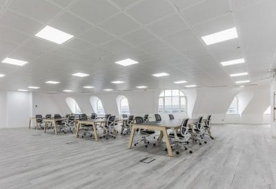 Spacious open-plan workspace featuring vaulted ceilings and multiple rows of desks.