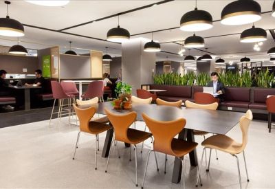 Communal dining area featuring stylish tan chairs and modern black pendant lighting.
