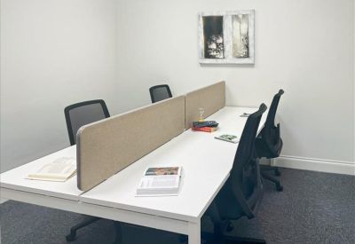 Private white office suite with a four-person desk and a partition.