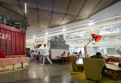 Breakout lounge with eclectic furniture and a red shipping container cafe.