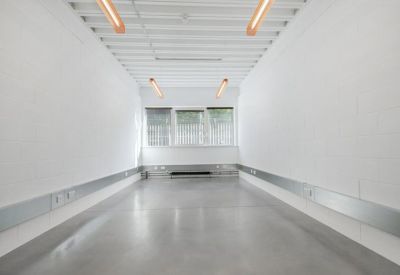 Bright empty office suite with white walls and a polished concrete floor.