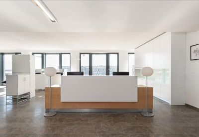 Minimalist reception area with a wood-fronted desk and clean white cabinets.