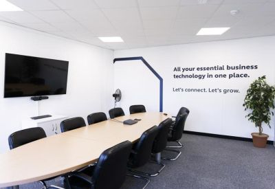 Modern meeting room featuring a wall graphic and a large screen for presentations.