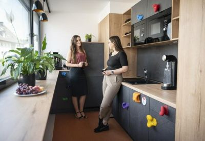 Modern communal kitchen with wooden counters and colorful climbing-hold handles.