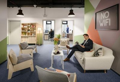 A colorful lounge area featuring modern armchairs, a white sofa, and No Wifi wall art.