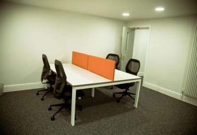 Four-person office suite with white desks and orange privacy screens.