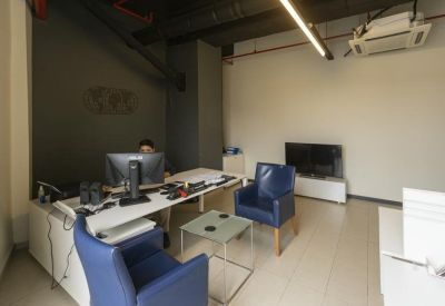 Reception area with blue armchairs and a modern white desk.