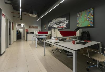 Open-plan workspace with multiple desks and colorful wall art.