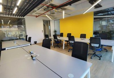 Open office area featuring a bright yellow accent wall and ergonomic chairs.