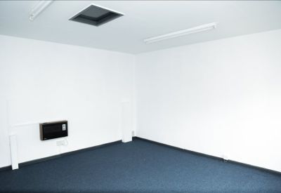 Brightly lit corner office space featuring white walls and a skylight.