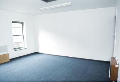 Internal office suite with clean white walls and blue commercial carpeting.