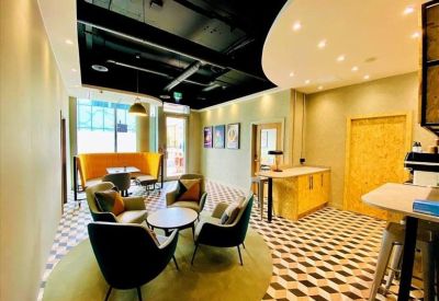 Lounge area with mid-century modern armchairs, a round coffee table, and checkered flooring.