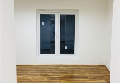Small room with wooden flooring and a single large window.