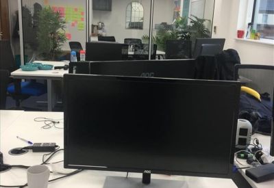 Bright office workspace featuring glass partitions and indoor plants.