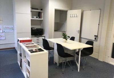 Internal meeting area with a white table, black chairs, and a whiteboard.