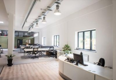 Contemporary meeting room or breakout area with glass walls and black exposed ceilings.