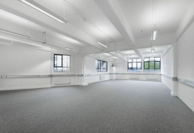 Bright, empty office room with white walls and dual-aspect windows.