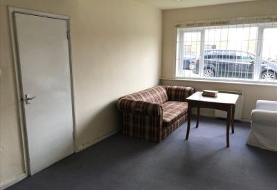 Internal view of a white office door with a silver handle in a neutral-toned room.