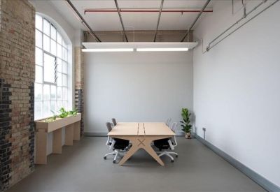 Minimalist office suite with a large arched window and light wood desk.