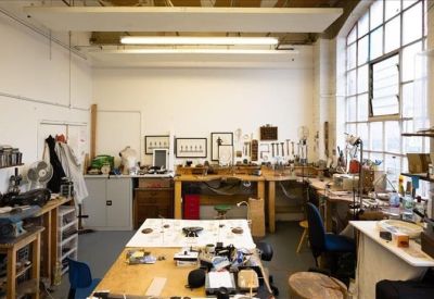 Creative workshop area with various tools, art supplies, and large windows.
