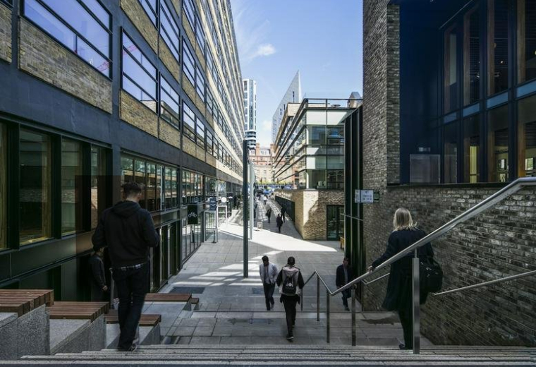 Modern stone stairs leading between office buildings with people walking.