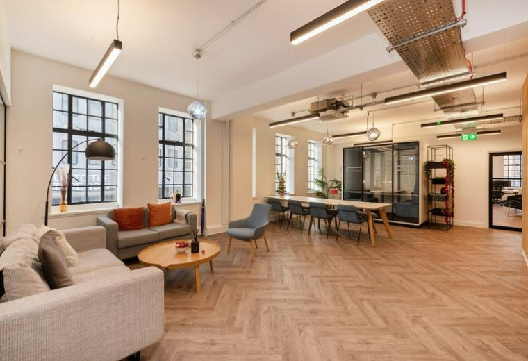 Spacious communal lounge at 29-31 Euston Road with parquet flooring and modern furniture.