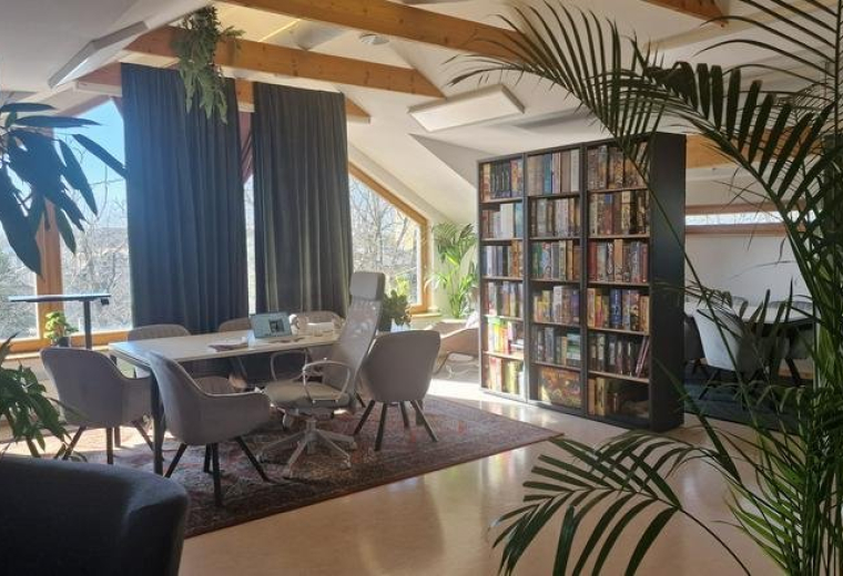 Spacious open-plan lounge and workspace at 34, Kivimurru tänav with vaulted ceilings and many plants.