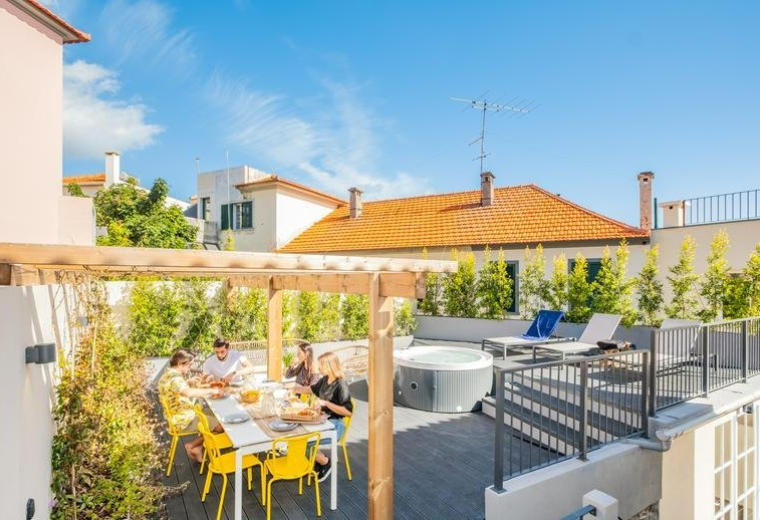 Sunny rooftop terrace at 42, Calçada do Pico, featuring a dining area, hot tub, and lounge chairs.