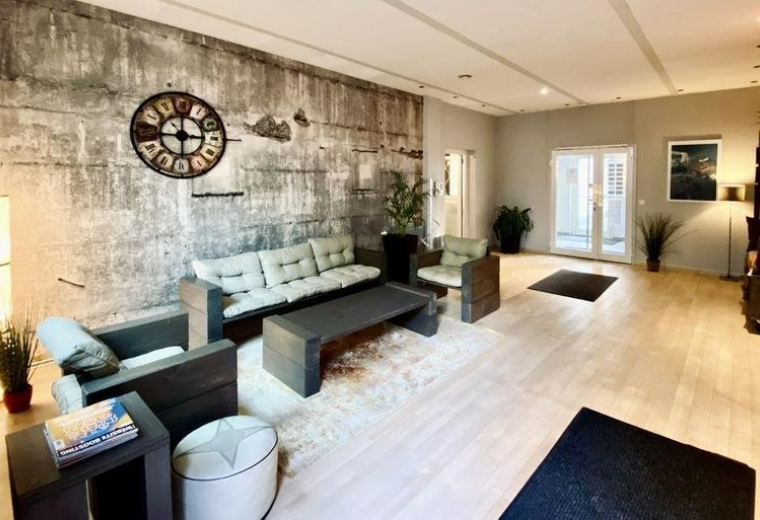Spacious communal lounge at 53, Hans-Henny-Jahnn-Weg with industrial feature wall and comfortable seating.