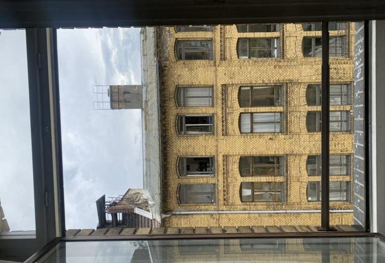 The classic yellow brick facade of the Brückenstraße building seen through a window.