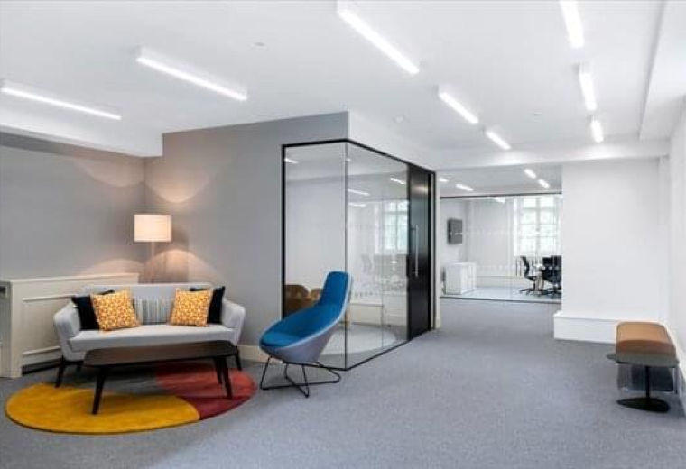 Modern reception lounge at 20 Grosvenor Place with a grey sofa and a bright blue accent chair.