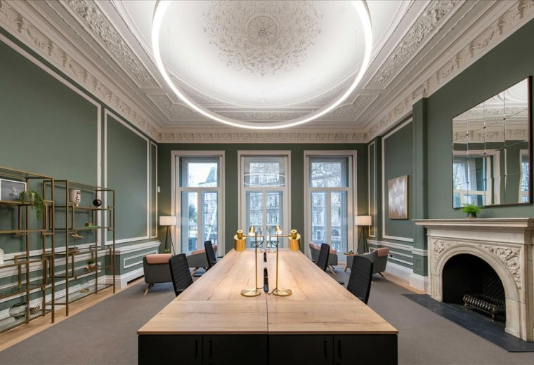 Grand shared workspace at 22 Grosvenor Gardens with ornate ceilings, green walls, and a large circular light.