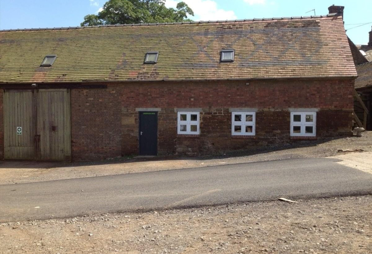 Exterior view of the brick facade and pitched roof at The Old Workshop, Cold Ashby Road, Guilsborough.