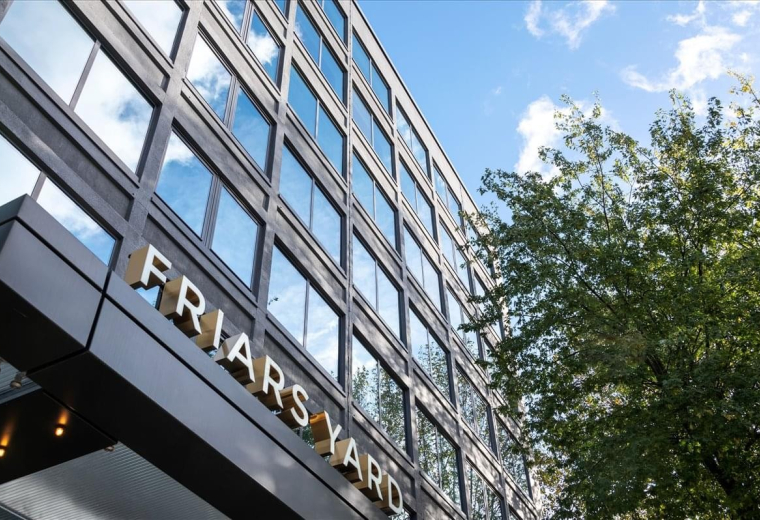 Exterior view of the glass-fronted Friars Yard building with mature trees.