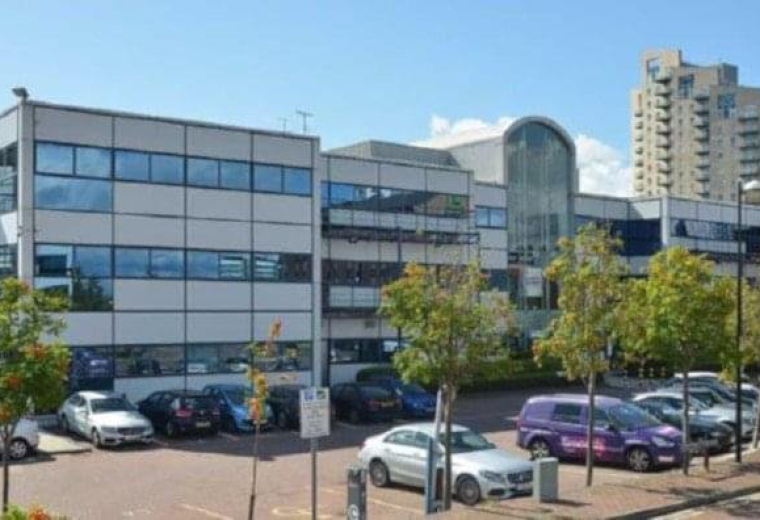 Exterior view of the modern glass and stone facade at Media Village, Waterfront Quay, Manchester.
