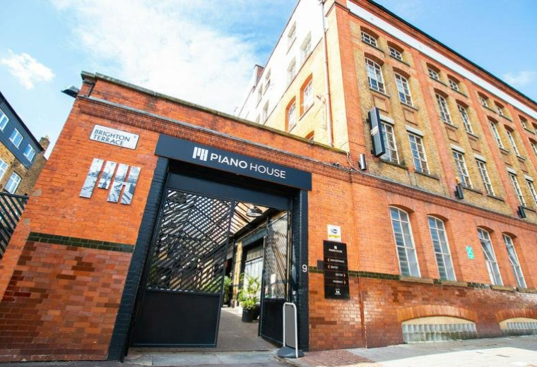 Exterior view of the red brick facade and gated entrance of Piano House.