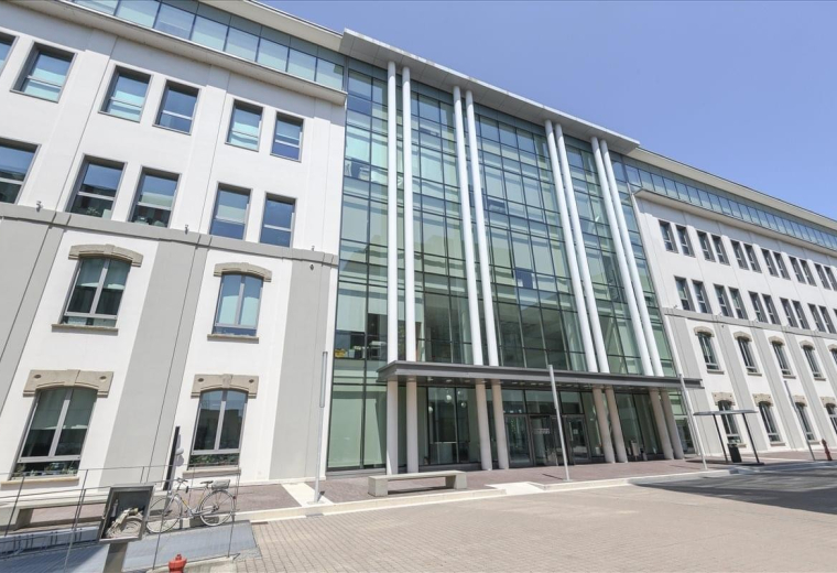 Exterior view of the modern glass and stone facade of the Mac4, Via Benigno Crespi 19 building.