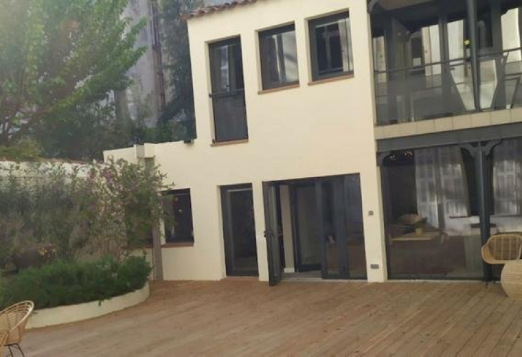 Exterior view of the white facade and courtyard at 18 rue Dieudé.