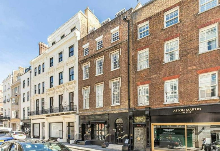 Classic brick and white stone facade of the multi-story building at 10, Dover Street, London.
