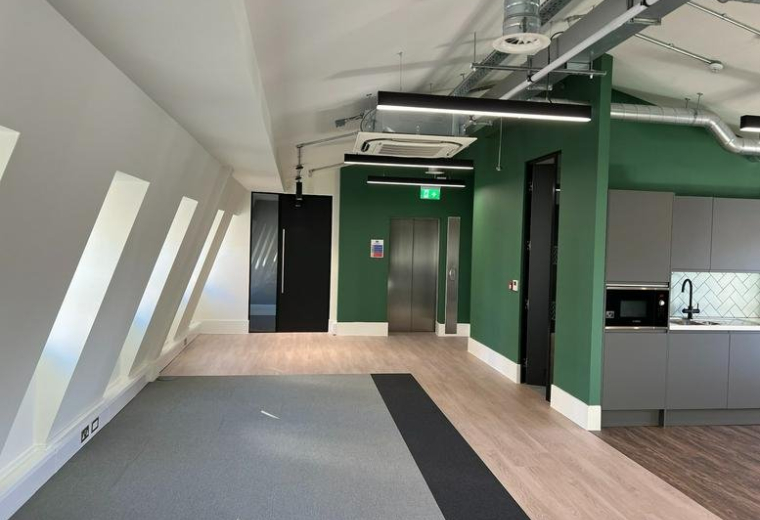 Spacious communal area at 107 Gray’s Inn Road with a modern kitchen, green feature walls and vaulted ceilings.