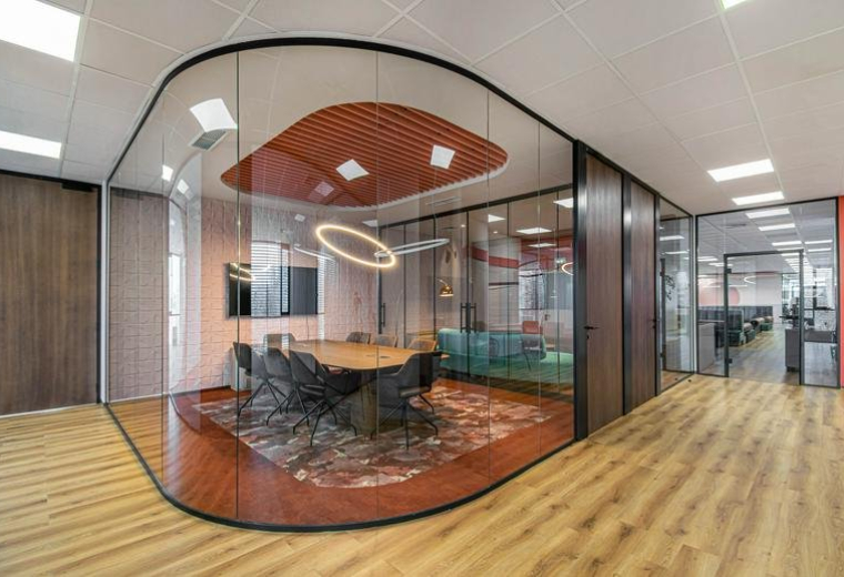 A modern curved glass meeting room at 111 Boulevard Tsarigradsko shose with a circular halo light and wooden table.