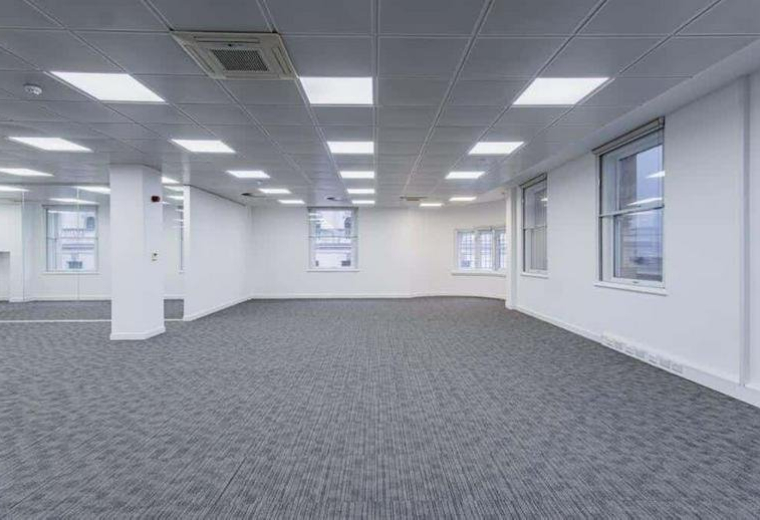 Large empty workspace featuring grey carpet and multiple windows.