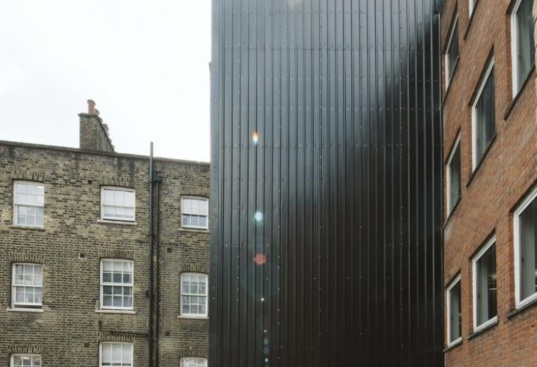 Modern exterior view of the dark ribbed facade at 222 Bishopsgate, London.