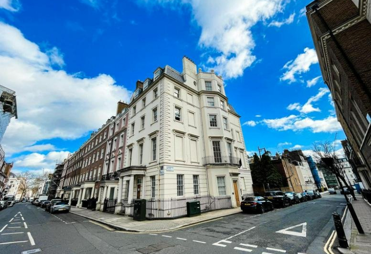 Exterior facade of the white corner building at 27 Hill Street.