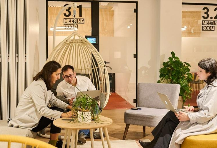 Exterior view of office building with modern facade and surrounding trees.