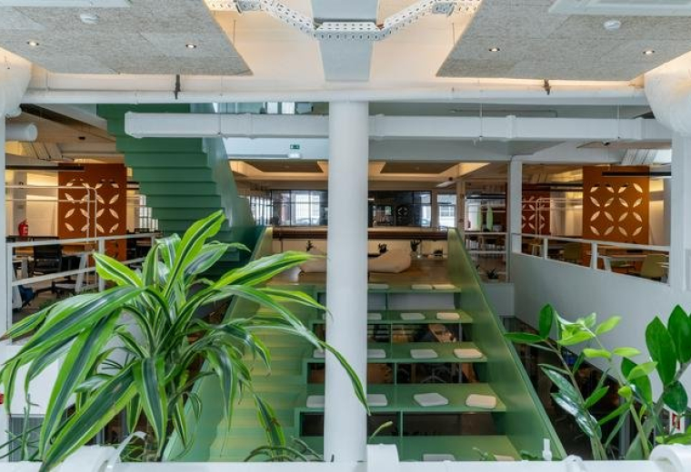 Spacious open-plan mezzanine at 45, Rua do Centro Cultural, Lisbon with lush green plants and modern lighting.