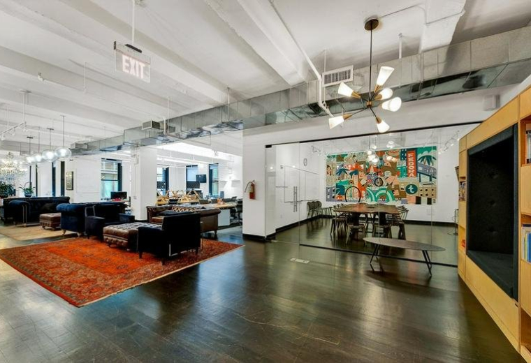 Spacious lounge at Floor 2, 45 Whitfield Street, Fitzrovia with polished wood floors and vibrant wall art.