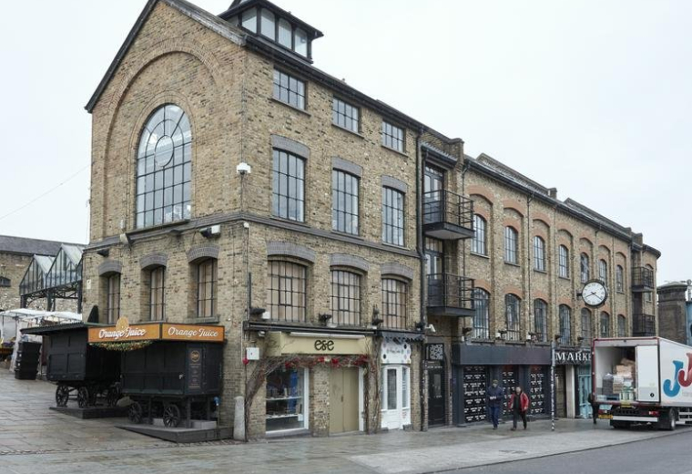 Exterior view of the brick facade at 54-56 Camden Lock Place featuring large arched windows.