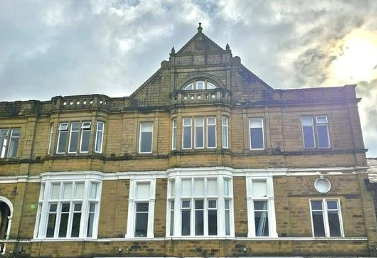 Exterior view of the historic stone facade at 57- 65 Burnley Road, Padiham, Lancashire.