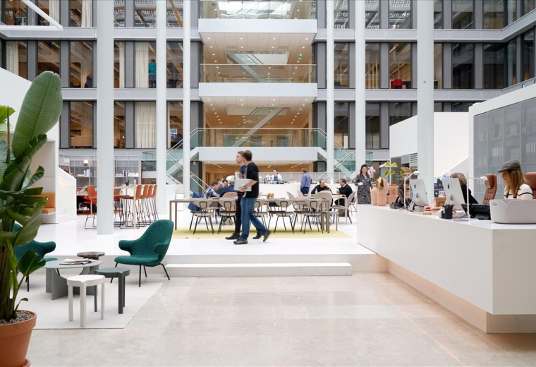 Grand multi-story atrium at 6 Liddell Place with glass railings and modern lounge seating.